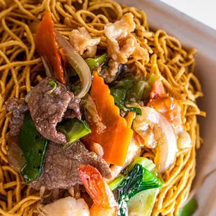 a plate of noodles with meat and vegetables