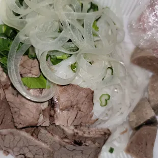 Brisket, meatball, and rare beef with garnish for Pho