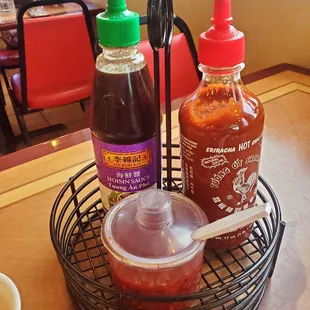 Hoisin &amp; sriracha sauces, along with chopped chiles in oil.