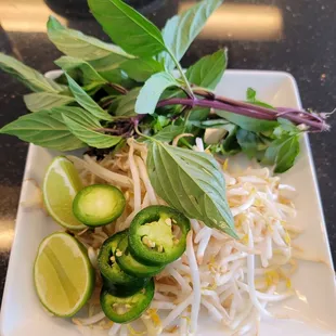 Fresh Thai basil, bean sprouts, and jalapeño peppers with lime.