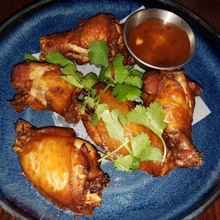  plate of chicken wings with a side of sauce