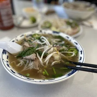 a bowl of soup with chopsticks