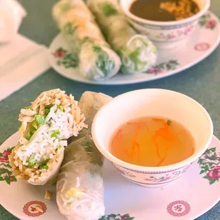 a bowl of soup and a plate of spring rolls