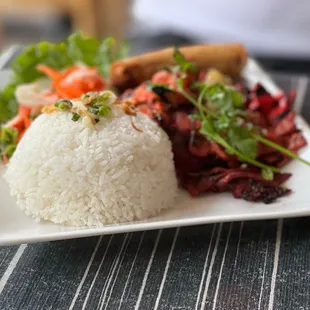 a plate of rice, meat and vegetables