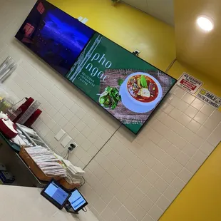 a restaurant counter with a menu on the wall
