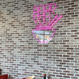 a neon sign on a brick wall