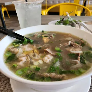 a bowl of soup with chopsticks