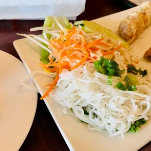 a plate of noodles, meat and vegetables