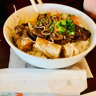 a bowl of noodles with meat and vegetables