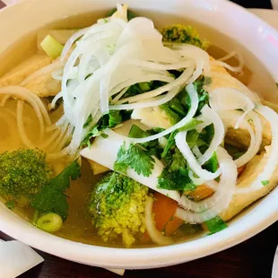 a bowl of soup with broccoli and noodles