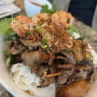 Vermicelli Noodles topped with pork and shrimp, with spring roll.