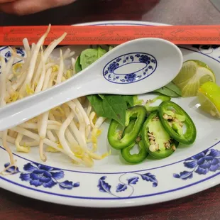 a plate of food with a spoon and chopsticks