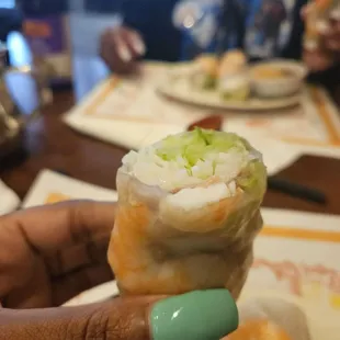 a person holding a roll of food