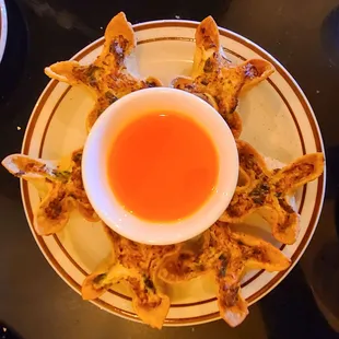 a plate of dumplings with dipping sauce