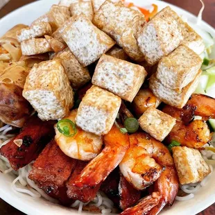 a bowl of noodles with tofu and shrimp