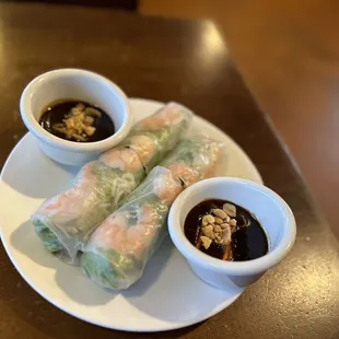 a plate of spring rolls with dipping sauce