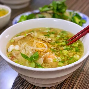 a bowl of soup with chopsticks