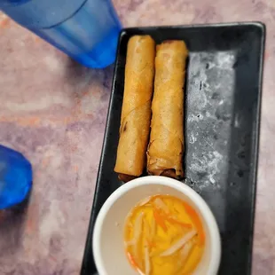 a plate of spring rolls and dipping sauce