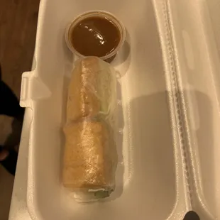 a plastic container with a sandwich and dipping sauce