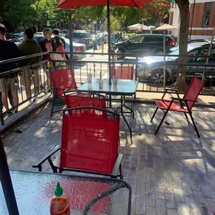 a patio with red chairs and umbrellas