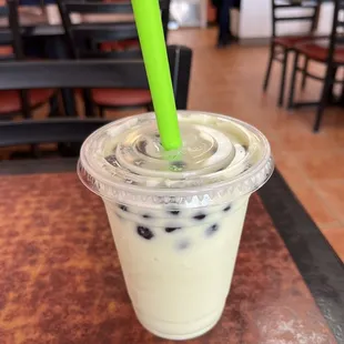 a drink in a plastic cup with a green straw