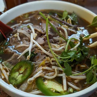 a bowl of soup with chopsticks