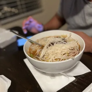 a bowl of noodles with chopsticks