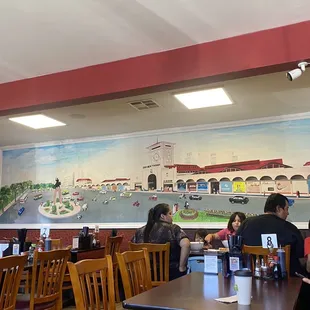 a restaurant with a mural on the wall