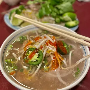 a bowl of soup with chopsticks