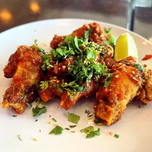 a plate of chicken wings with garnish
