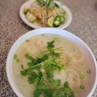 a bowl of soup and a plate of noodles