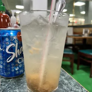 a cold drink with ice and a straw