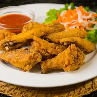 a plate of fried chicken with a side of salad