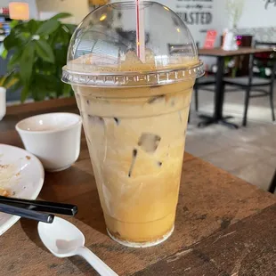 a iced coffee with a straw in a plastic cup