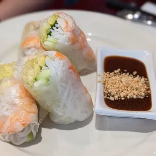 a plate of sushi rolls with dipping sauce