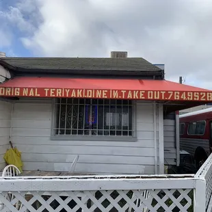 a white house with a red awning