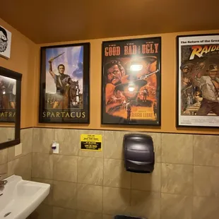 a bathroom with posters on the wall