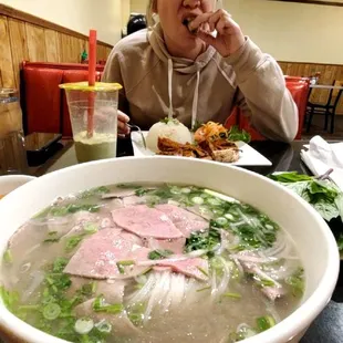 a woman eating a bowl of soup