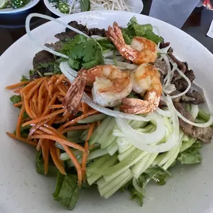 a plate of salad with shrimp and vegetables