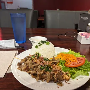 Grilled pork with vegetables over white rice and water