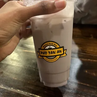 a hand holding a cup of iced coffee