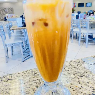 a glass of iced coffee on a table