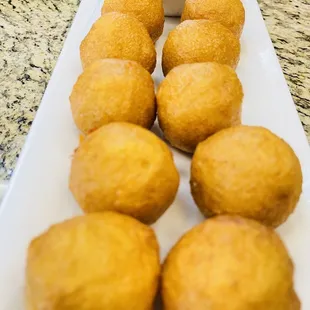 a plate of deep fried donuts with dipping sauce