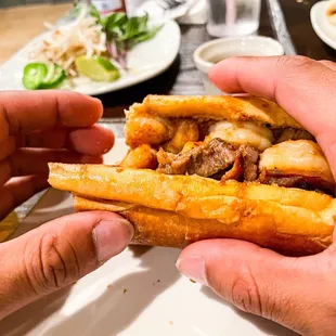 two hands holding a sandwich