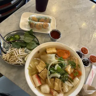 Vegetarian soup with added seafood and shrimp spring rolls with sweet chili sauce