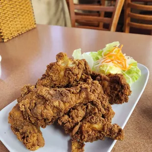 a plate of fried chicken and a salad