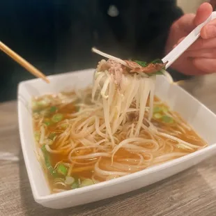 a bowl of noodles and chopsticks