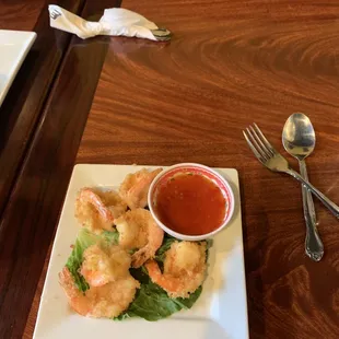 a plate of shrimp with dipping sauce