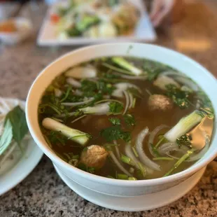 a bowl of soup and a plate of noodles
