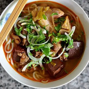 Bun Bo Hue ( spicy beef, pork blood, pork feet, tendon, steamed pork, noodle, green onion, white onion and cilantro )